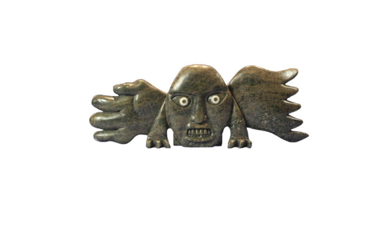 One original inuit art sculpture hand carved by Toonoo Sharky in serpentine ''Face Wings'' from Cape Dorset, Nunavut.