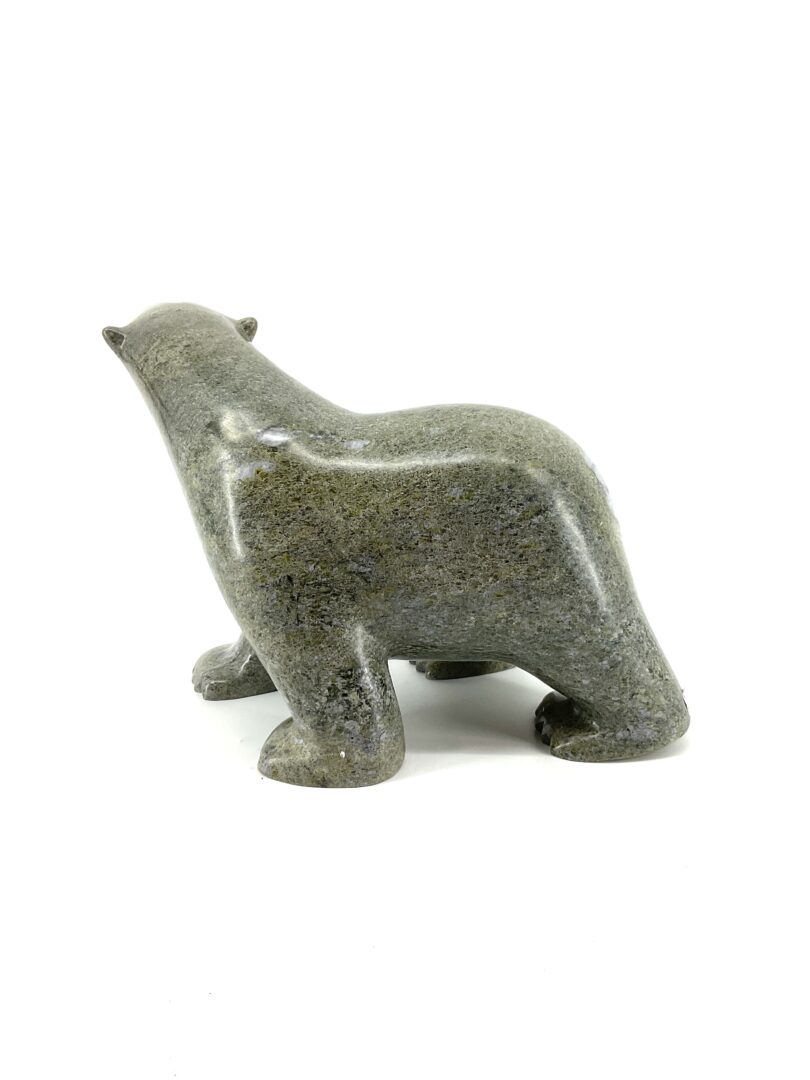 One original hand-carved sculpture by Ashevak Adla from Cape Dorset, Nunavut. One walking bear carved out of green serpentine.