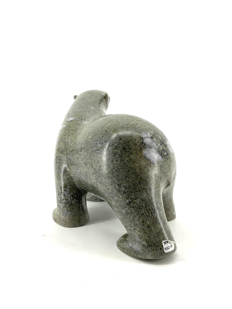 One original hand-carved sculpture by Ashevak Adla from Cape Dorset, Nunavut. One walking bear carved out of green serpentine.