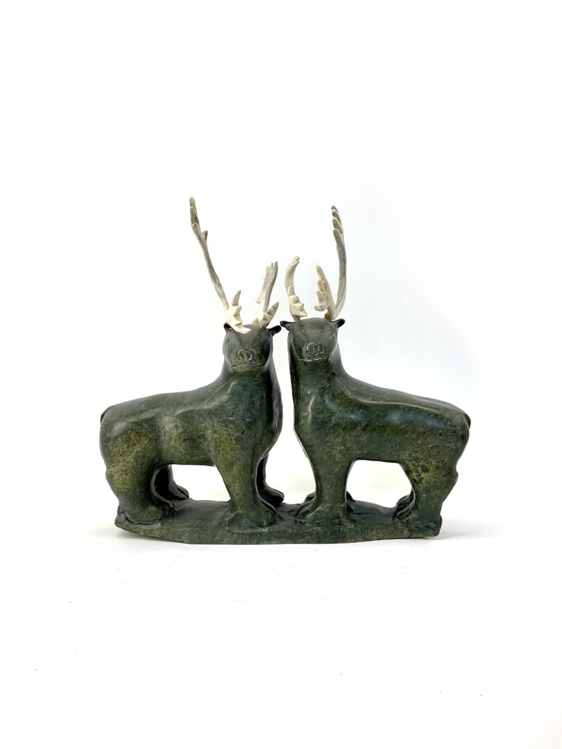 One original hand-carved sculpture by Tim Alivaktuk from Pangnirtung, Nunavut. Two caribous made out of serpentine and caribou antler.