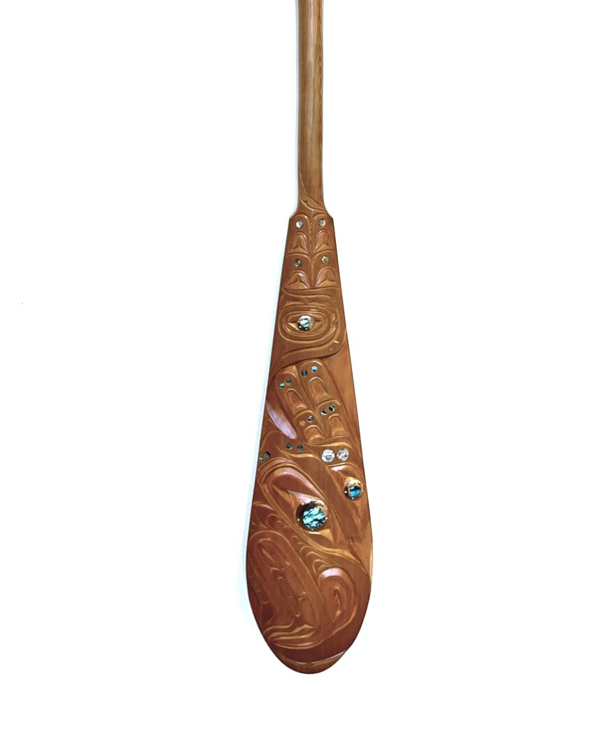 One original hand-carved paddle made out of cedar wood with copper and abalone inlay, by Troy Kwakseesthala from Weiwakum.