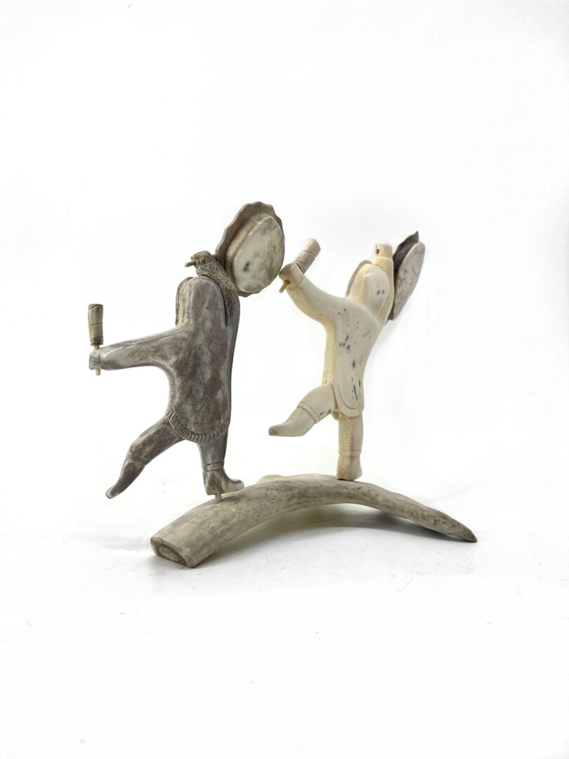 One original hand-carved sculpture by Guy Nutarariaq from Pond Inlet, Nunavut. Father and son sculpture made out of caribou antler.