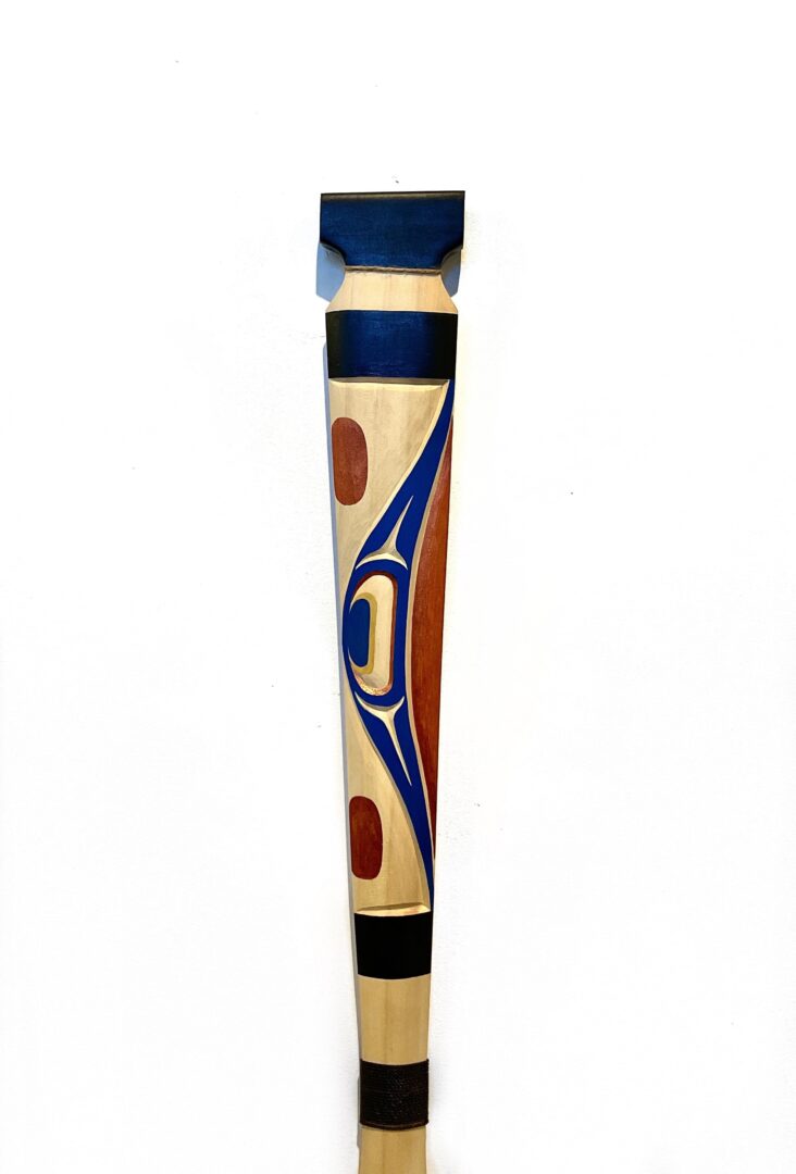 One hand-carved cedar wood paddle with acrylic paint by Indigenous artist Jason Henry Hunt from Kwakwaka'wawk.