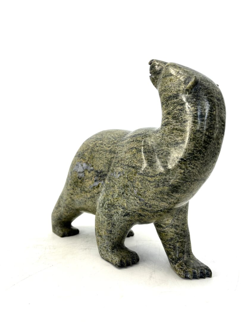 One original hand-carved sculpture by Inuit artist Time Pee. Walking bear sculpted out of green serpentine.
