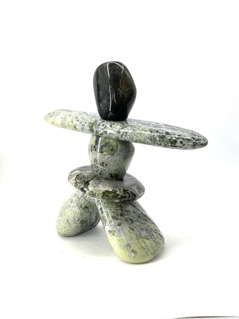 One original hand-carved sculpture by Ojibway artist, Paul Bruneau. One inukshuk sculpture made out of serpentine.