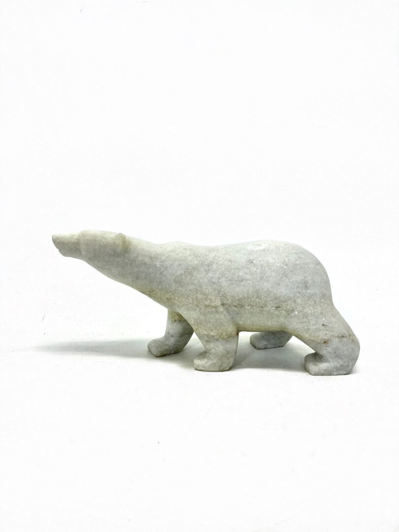 One original hand-carved sculpture by Inuit artist, Tim Pee. One walking bear made out of Canadian white marble.