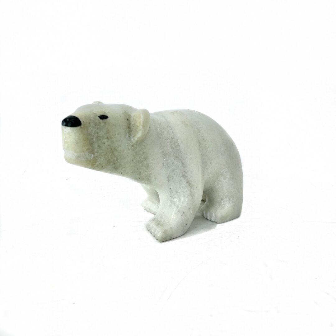 One original hand-carved sculpture by Inuit artist Guy Uniqsaraq. One walking bear sculpture made out of white marble.