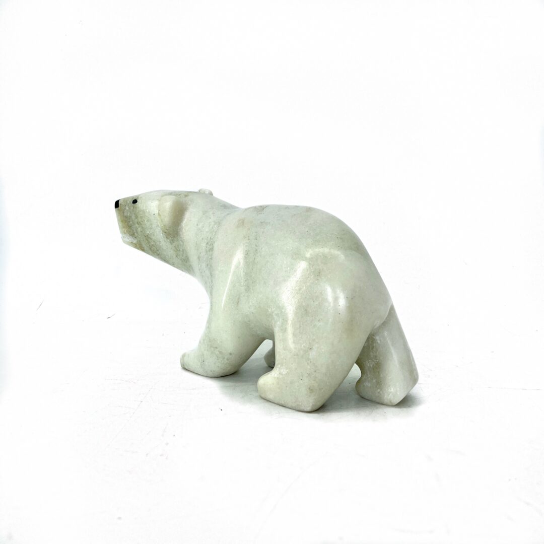 One original hand-carved sculpture by Inuit artist Guy Uniqsaraq. One walking bear sculpture made out of white marble.