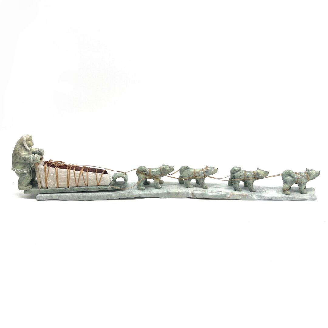 One original hand-carved sculpture by Inuit artist, Peter John Mitchell. One dog sled sculpture made out of soapstone.