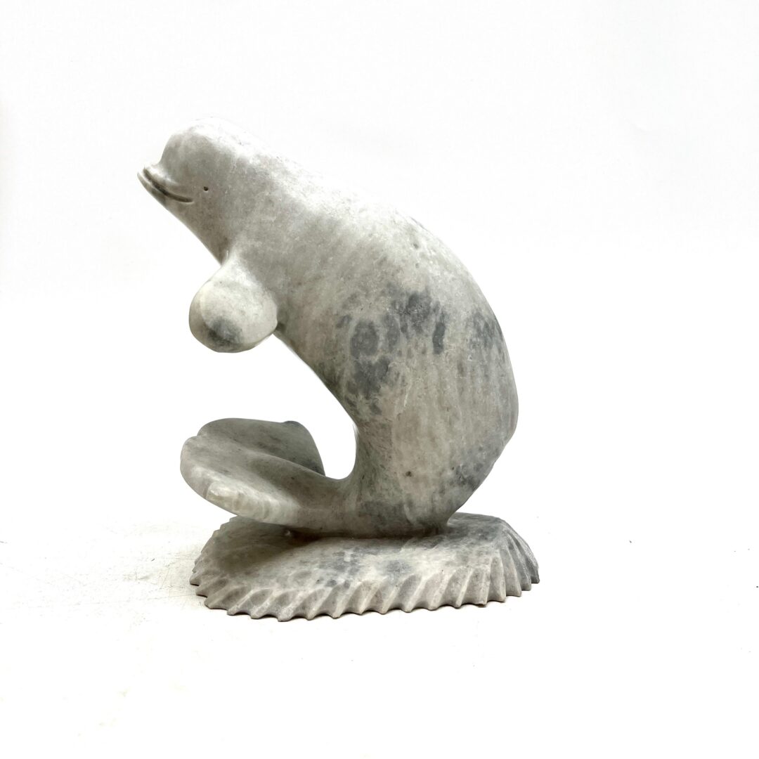 One original hand-carved sculpture by Inuit artist, Dan Aula. One whale and base made out of white marble.