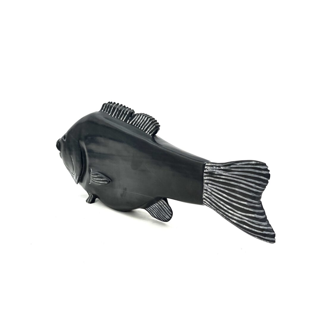 One original hand-carved sculpture by Inuit artist, Sheokjuk Carriere. One small mouth bass fish made out of serpentine.
