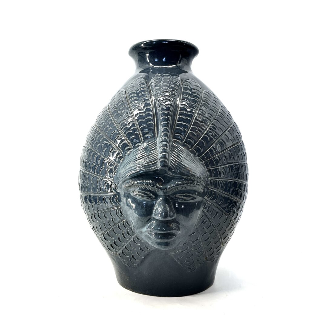 One original hand-carved vase by Inuit artist, Yvo Samgushak. One vase with a shaman's face sculpted in clay.