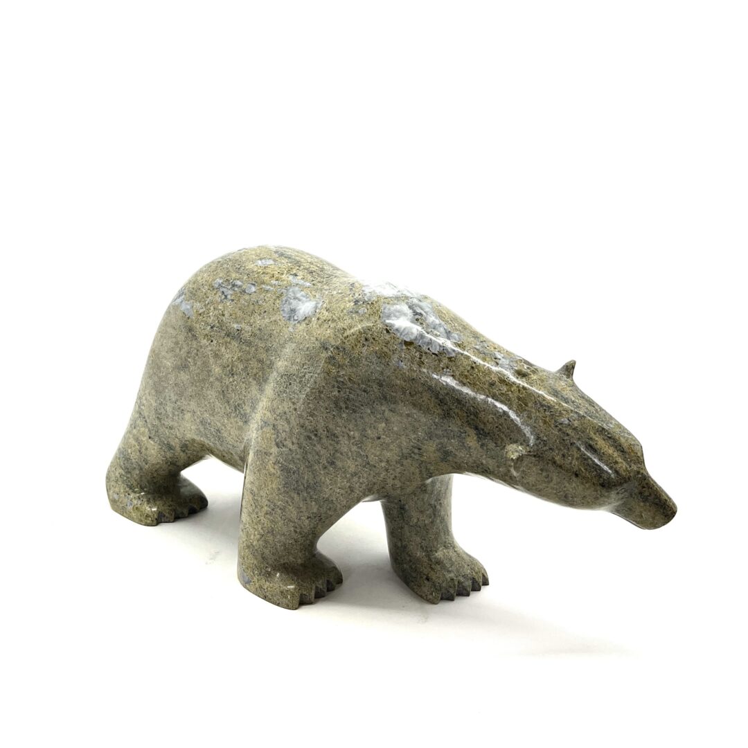 One original hand-carved sculpture by Inuit artist, Ashevak Adla. One walking bear carved out of serpentine.