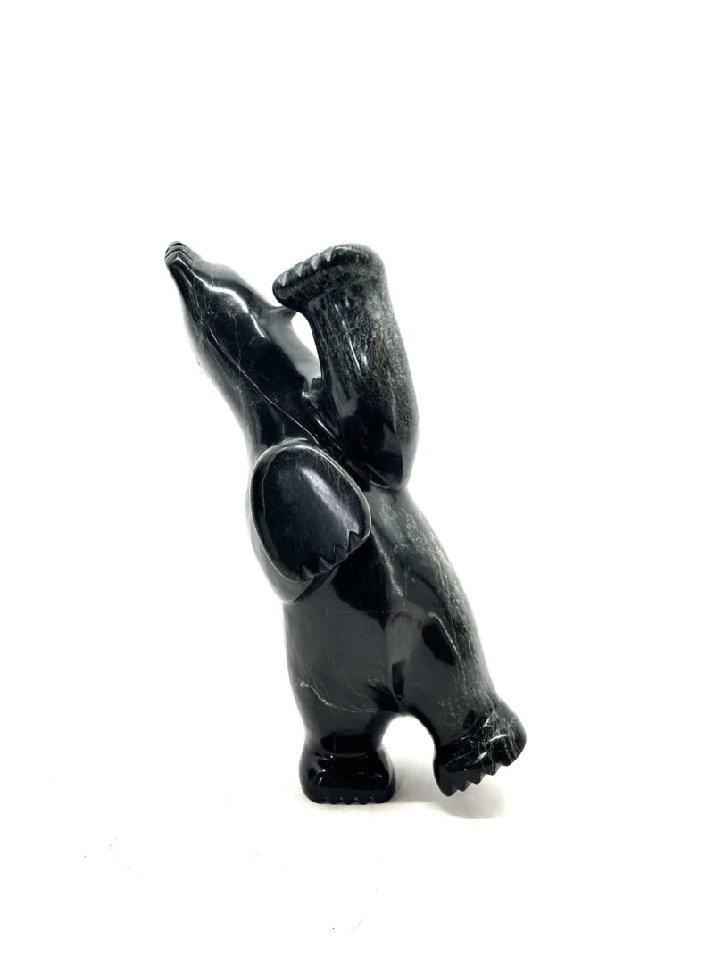 One original hand-carved sculpture by Inuit artist, Etidloie Adla. One dancing bear carved out of serpentine.