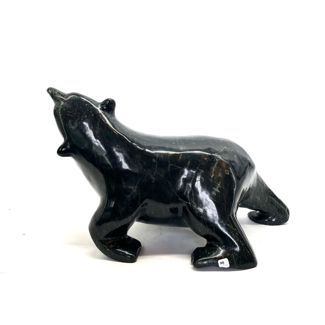 One original hand-carved sculpture by Inuit artist, Nuna Parr. One walking bear sculpture carved out of serpentine.