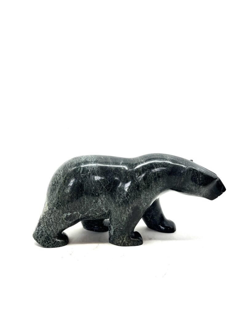 One original hand carved sculpture by Inuit artist Etidloie Adla. One walking bear carved out of serpentine.