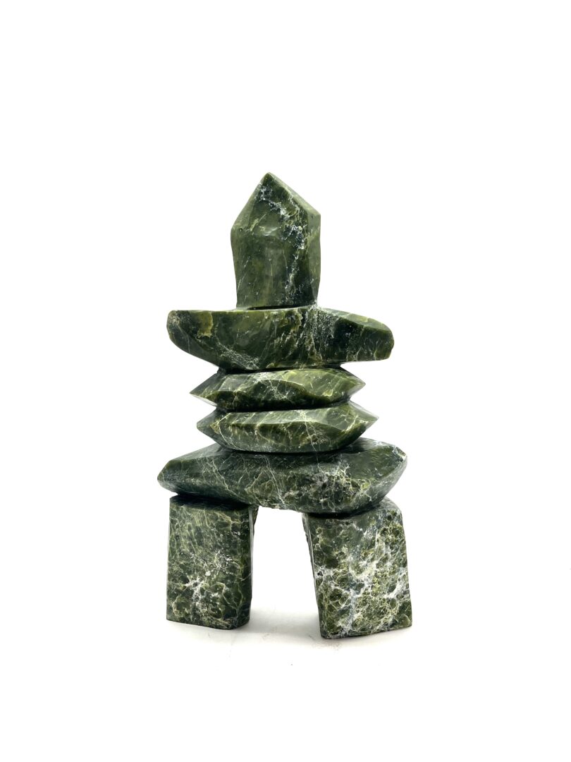 One original hand-carved sculpture by Inuit artist, Willie Kolola. One inukshuk sculpture carved out of serpentine.