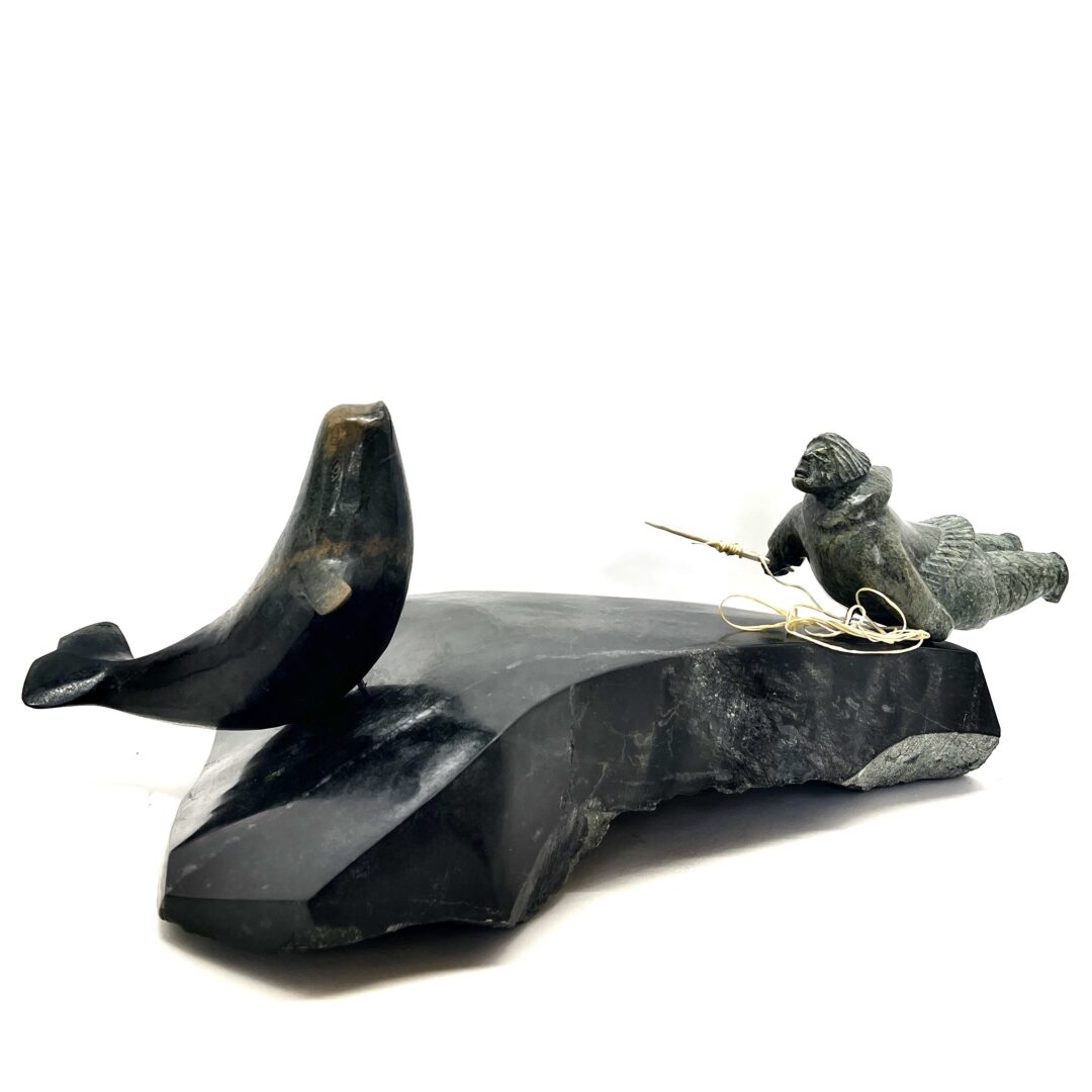 One original hand-carved sculpture by Inuit artist, Jaco Ishulutak. One hunter and whale carved out of serpentine.