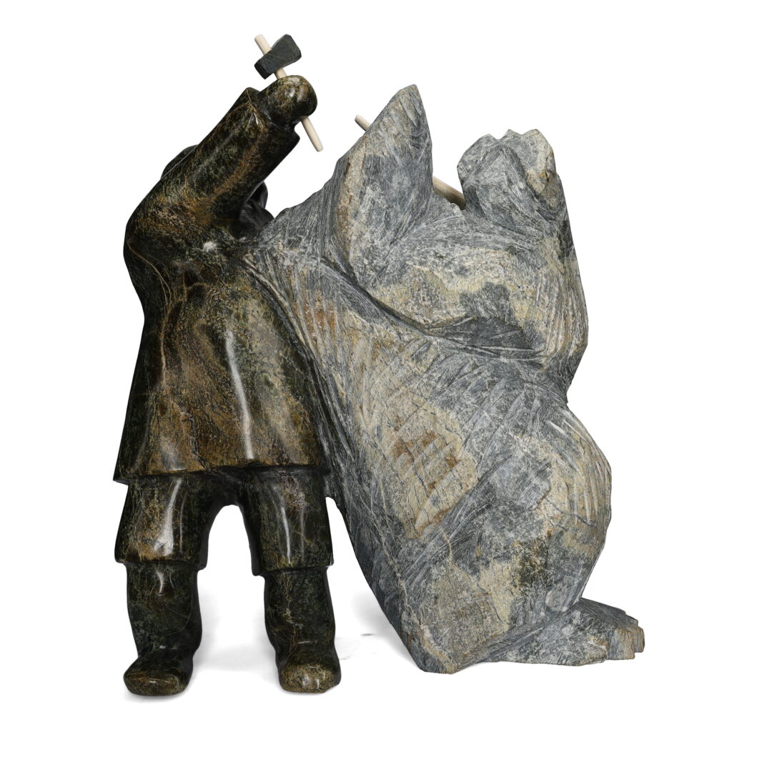 One original hand-carved sculpture by Inuit artist Kelly Qimirpik. One man carving walrus made of serpentine stone.