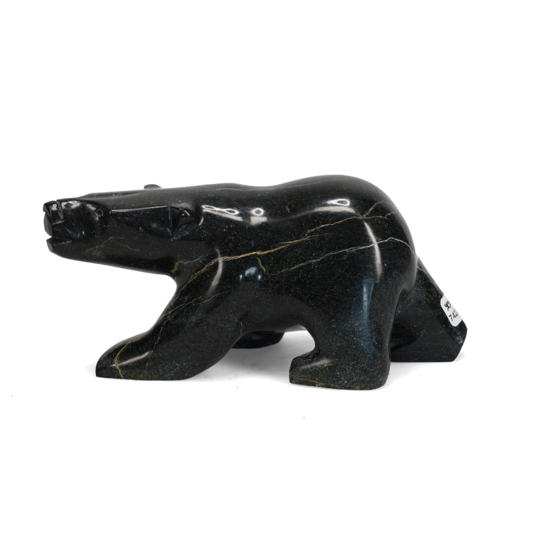 One original hand-carved sculpture by Inuit artist Joanie Ragee. One walking bear carved out of serpentine.