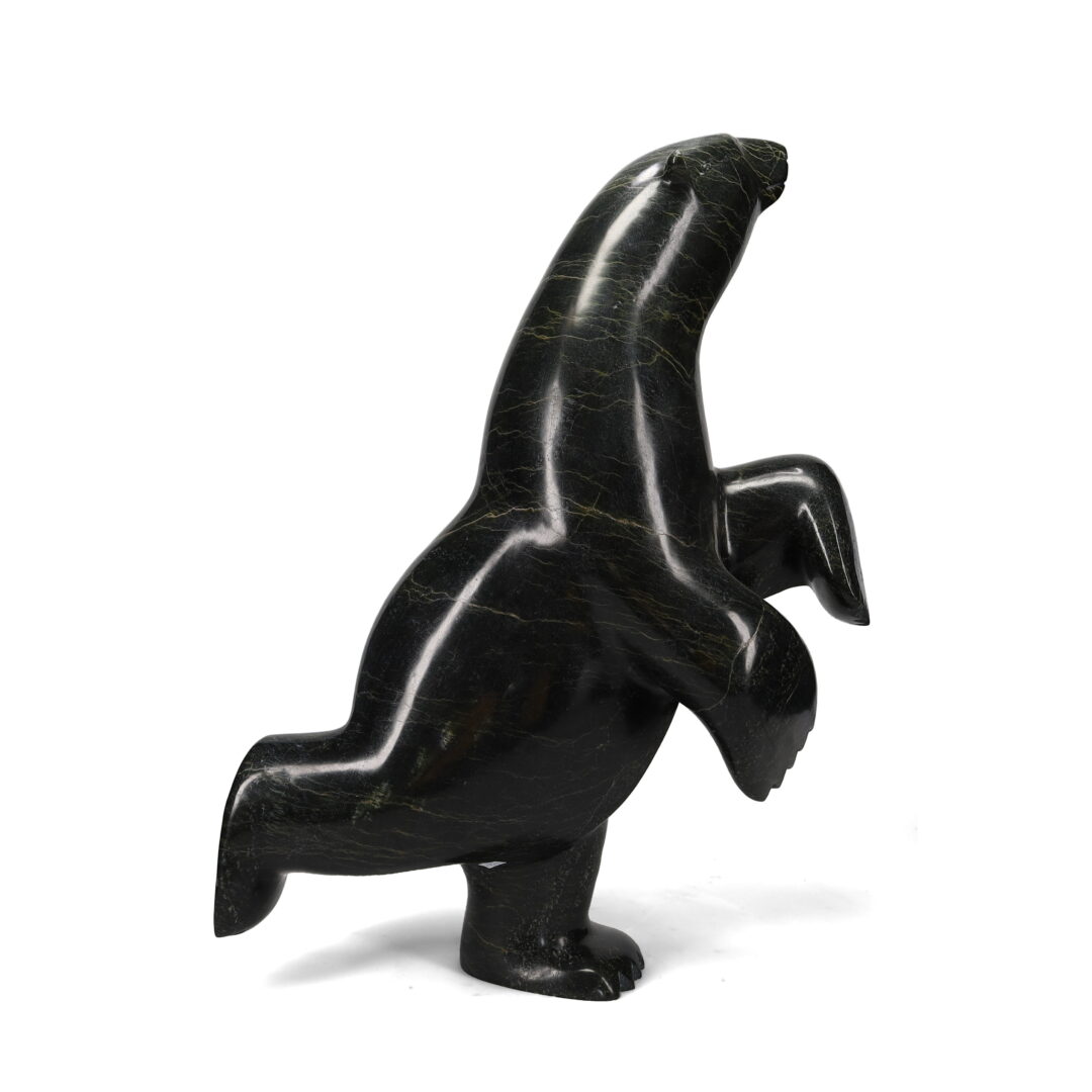 One original hand-carved sculpture by Inuit artist Ashevak Adla. One dancing bear carved out of serpentine stone.