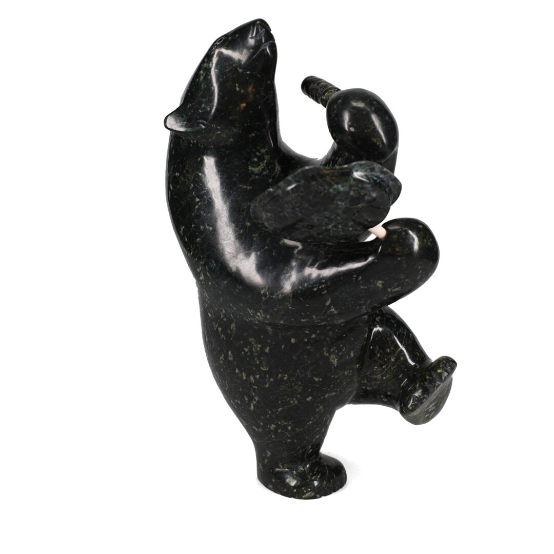 One original hand-carved sculpture by Inuit artist Etidloie Adla. One drum dancing polar bear carved out of serpentine.