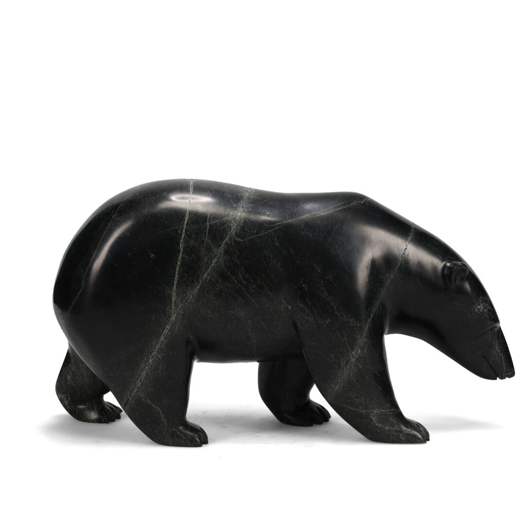 One original hand-carved sculpture by Inuit artist Noah Jaw. One walking bear carved ouf of serpentine stone.