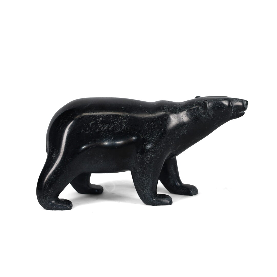 One original hand-carved sculpture by Inuit artist, Tim Pee. One walking bear carved out of serpentine stone.