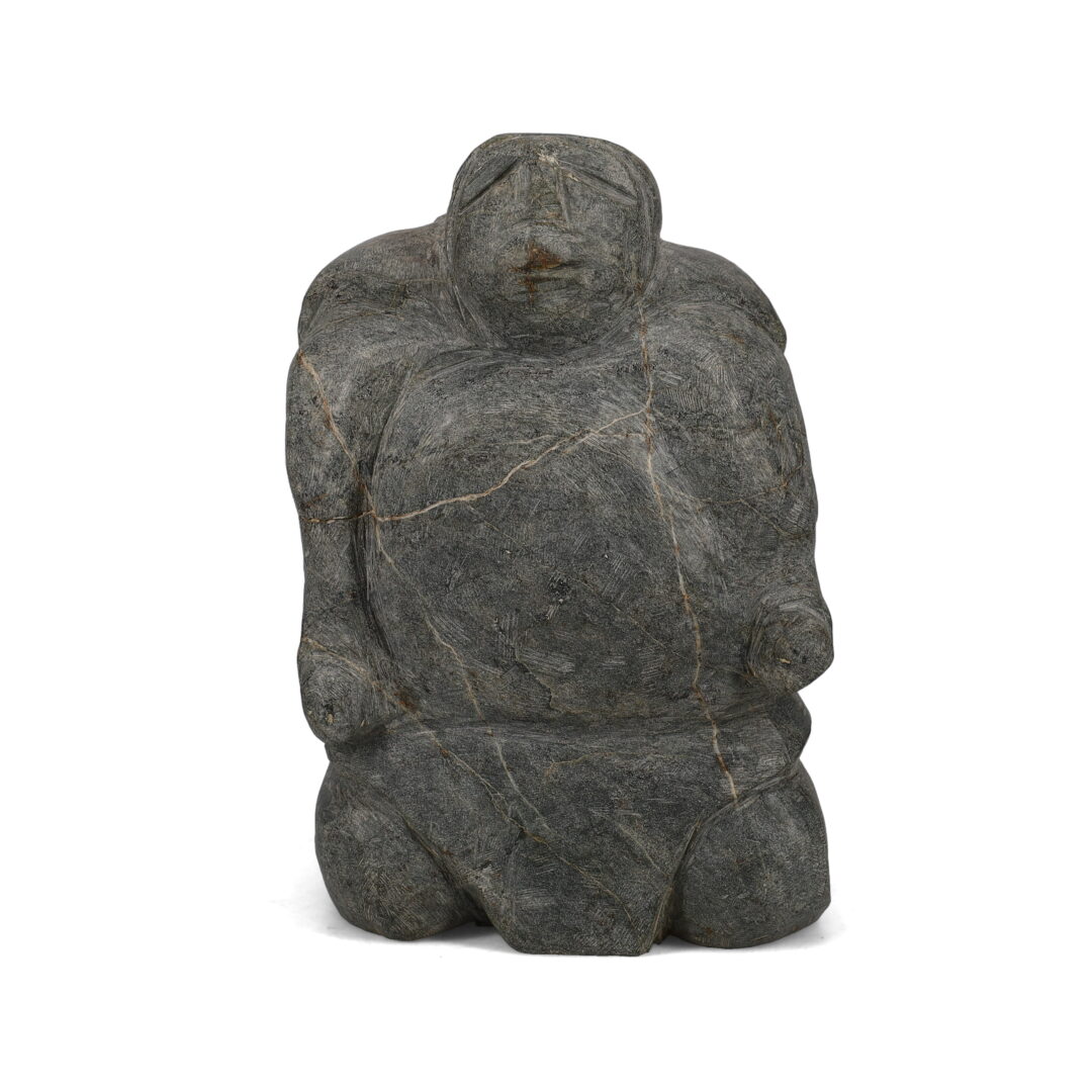 One original hand-carved sculpture by Inuit artist, Tuna Iquliq. One woman carved out of grey basalt stone.