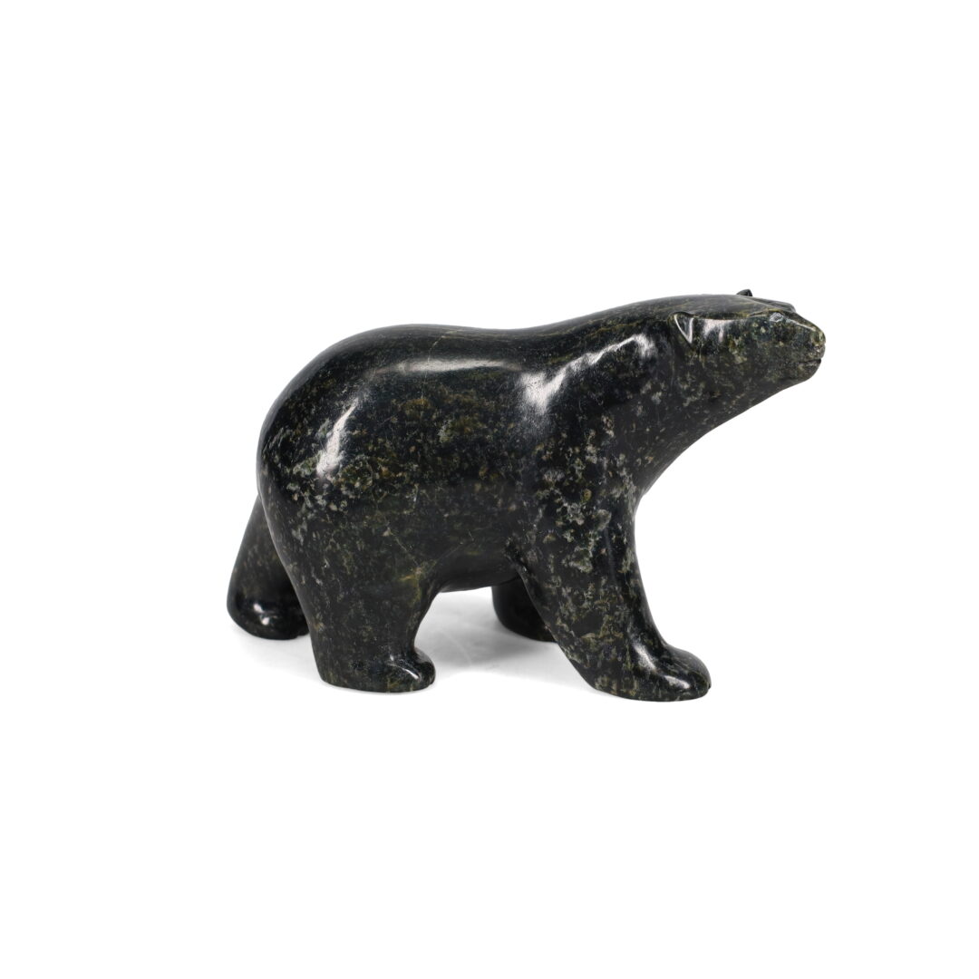 One original hand-carved sculpture by Inuit artist, Etidloie Adla. One walking bear carved out of serpentine.