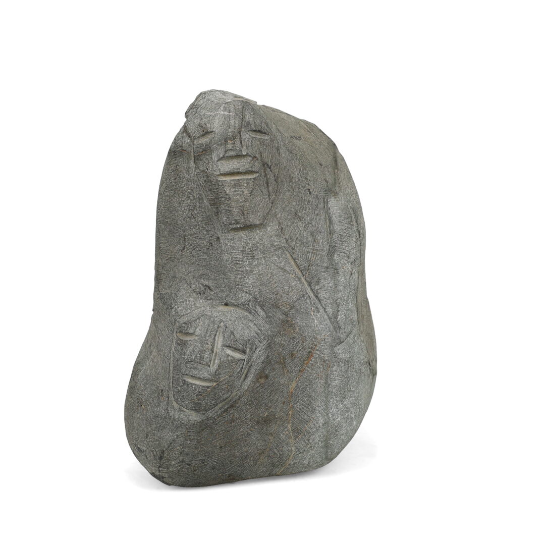 One original hand-carved sculpture by Inuit artist, Lucy Tasseor. One collection of faces carved out of basalt.