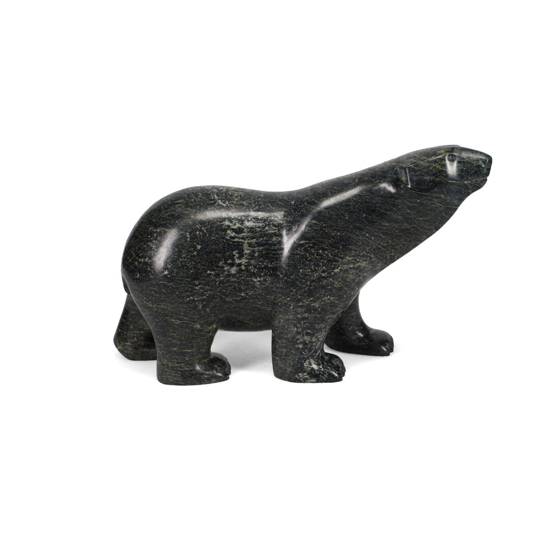 One original hand-carved sculpture by Inuit artist, Ashevak Adla. One walking bear carved out of serpentine.