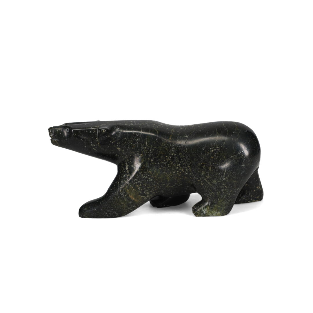 One original hand-carved sculpture by Inuit artist, Joanie Ragee. One walking bear carved out of serpentine.One original hand-carved sculpture by Inuit artist, Joanie Ragee. One walking bear carved out of serpentine.