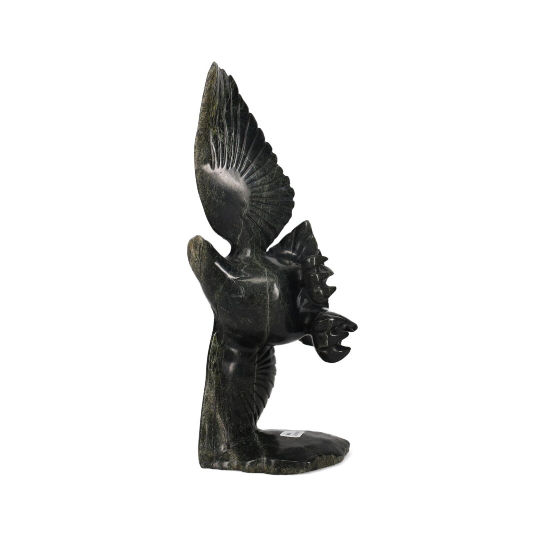 One original hand-carved sculpture by Inuit artist, Kellypalik Etidloie. One flying eagle carved out of serpentine.