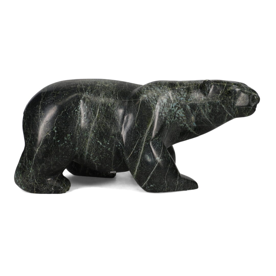 One original hand-carved sculpture by Inuit artist, Isacie Petaulassie. One walking bear carved out of serpentine.
