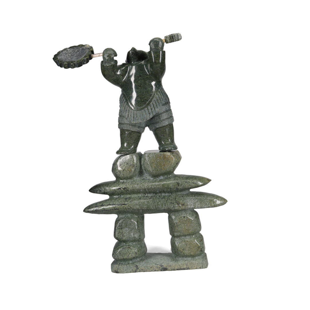 One original hand-carved sculpture by Inuit artist, Jaco Ishulutak. One drummer on inukshuk carved out of serpentine.