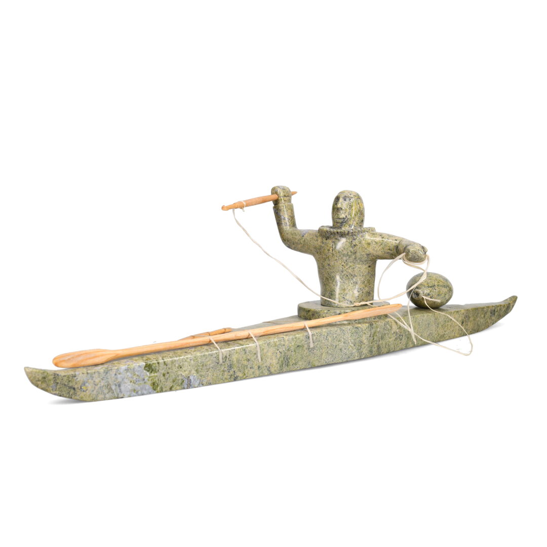 One original hand-carved sculpture by Inuit artist, Noah Jaw. One kayaker carved out of serpentine and wood.