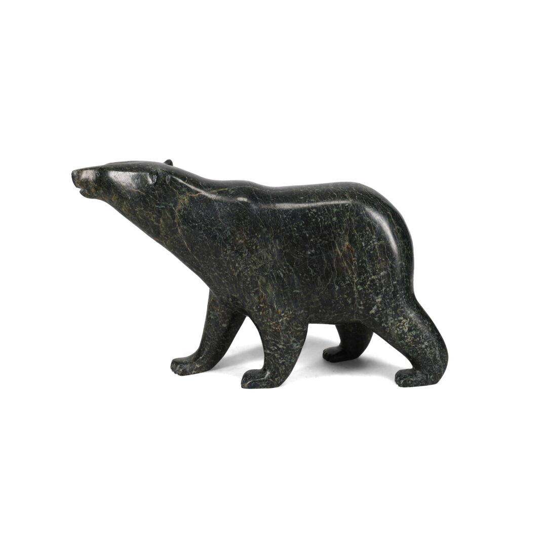 One original hand-carved sculpture by Inuit artist, Timothy Pee. One walking bear carved out of serpentine.